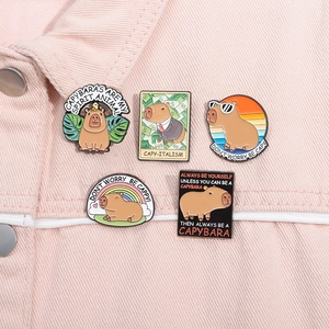Set of 5 creative capybara enamel pins with cute cartoon designs on pink denim fabric