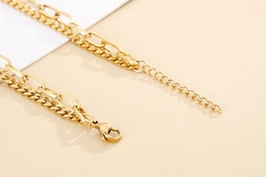 Detailed close-up of golden double-layer necklace showing lobster clasp and extension chain