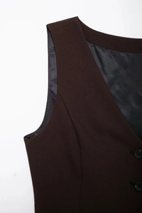 Détail d'un gilet sans manches marron foncé avec col en V et texture de tissu fine