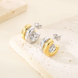 Gros plan de boucles d'oreilles en C bicolores plaquées or 18 carats sur pierre