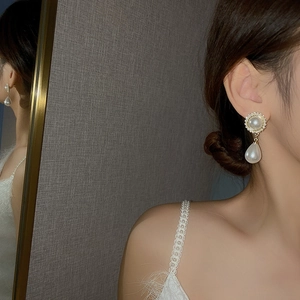 Boucles d'oreilles perles vintage françaises avec bord doré portées par un mannequin