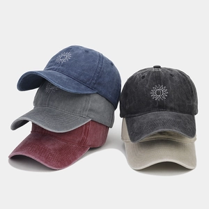 Détail de casquettes en coton délavé avec logos de tournesol brodés en divers coloris