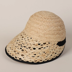 Detail of raffia straw lolita hat featuring hollow weave brim and black ribbon trim