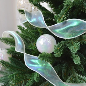 Iridescent white satin ribbon and pearl white snowflake ornaments on a lush Christmas tree