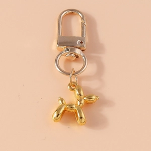 Macro detail of golden balloon dog keychain with spring lobster clasp and polished finish