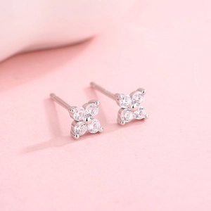 Macro detail of silver four-leaf clover earrings with sparkling cubic zirconia inlay