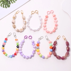 Close-up of seven colorful acrylic beaded phone straps with assorted imitation pearls