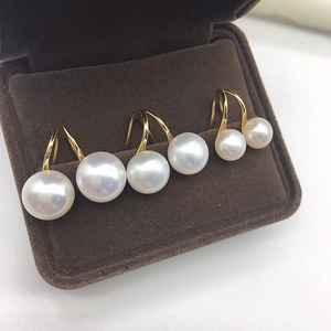 Macro shot of three pairs of classic white freshwater pearl earrings with gold hooks