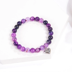 Close-up of purple beaded stone bracelet with silver heart charm on white display