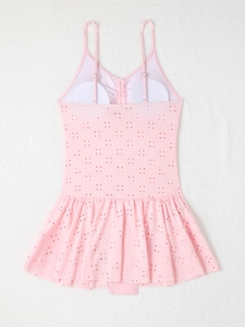 Detailed view of pale pink eyelet embroidery fabric on a ruffled swim dress