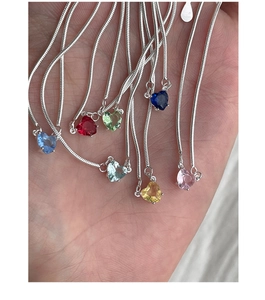 Dettaglio di pendenti a cuore colorati in zircone su una catena a serpente in argento S925