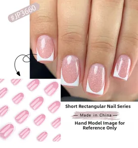 Short square press on nails with pink glitter base and white French tips detail
