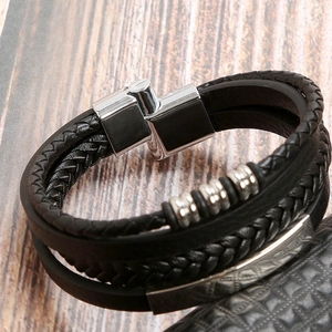 Detailed close-up of multilayer black leather woven bracelet with silver magnetic metal clasp