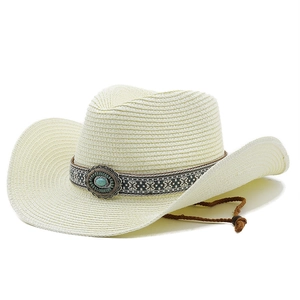Detail of turquoise ornament and ethnic ribbon on off-white straw western cowboy hat