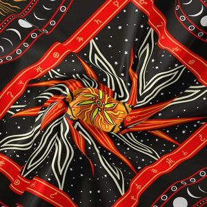 Makroaufnahme von Köperstoff mit astrologischen Mustern und Sonnenmotiv-Detail
