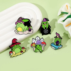 Detailed close-up of magic frog enamel pins with wizard hats and witch potion cauldrons