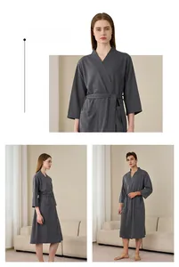 Close-up of deep grey waffle weave fabric texture on a long-sleeved bathrobe with belt