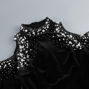 Close-up of black velvet dress with elegant white pearls and rhinestone embellishments