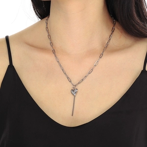 Détail du collier chaîne trombone en acier inoxydable argenté avec pendentif cœur à franges