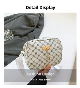 Close-up of beige monogram small square bag featuring a gold deer charm and chain detail