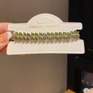 Detail of double-row bracelet with heart-cut green stones and silver finish