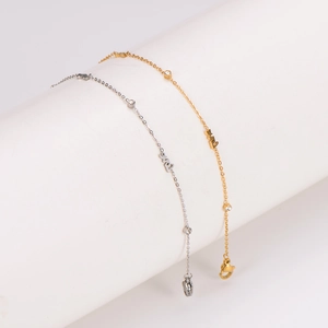 304 stainless steel gold and silver LOVE anklets with diamonds on a white display stand