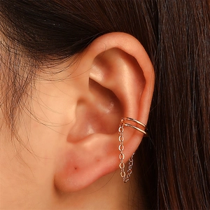 Eleganter 18K Gold Doppel-Ohrclip mit zarter Kettenquaste am Ohr des Models