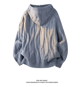 Detailed cable knit pattern on light blue-grey oversized hoodie with warm natural lighting