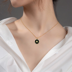 Gold titanium mermaid tail necklace with black enamel circular pendant for women