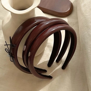 Three premium deep brown faux leather headbands with metallic accents in INS style