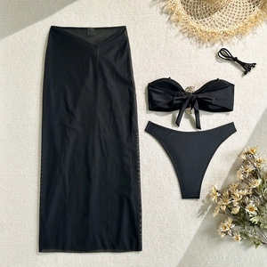 Three-piece black bikini set with metal ring detail and sheer mesh sarong skirt