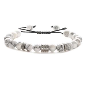 Detailed shot of white turquoise beads with stainless steel accents on a braided cord