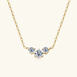 Macro shot of three round-cut Moissanite stones on a delicate gold S925 silver necklace