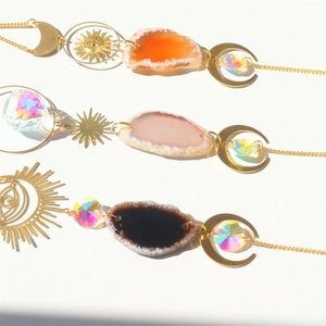 Close-up of golden sun catchers with agate slices and faceted crystal prisms