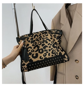 Detail showing leopard print tote with rivet studs and tassels on a canvas shoulder bag
