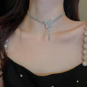 Gros plan d'un collier papillon argenté multicouche porté par un mannequin