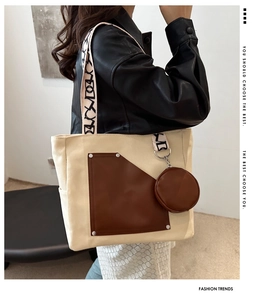 Detail of canvas tote bag with brown leather patchwork and geometric pattern strap