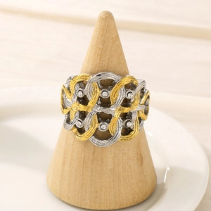 Gros plan d'une bague bicolore sertie de diamants sur un support conique en bois