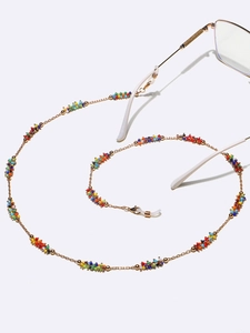 Detailed close-up of a handmade golden eyeglasses chain with colorful beads in a spiral layout