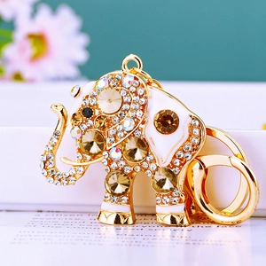 Close-up of golden elephant keychain with sparkling crystal rhinestones and white enamel finish