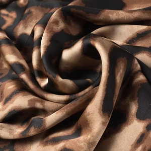 Macro shot of smooth leopard print satin fabric with glossy finish and elegant drapes