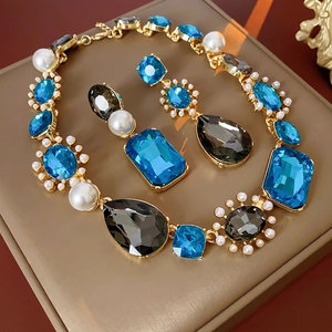 Vintage jewelry set with blue teardrop crystals and pearls on gold necklace and earrings