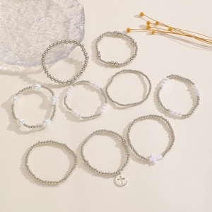 Dettaglio di un set di 10 braccialetti con perline, perle e ciondoli a croce d'argento