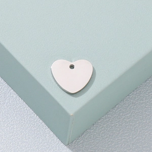Minimalist heart-shaped stainless steel pendant with a single hole in silver finish