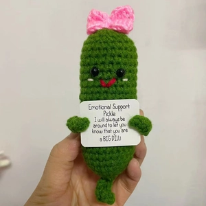Detail of hand-knitted emotional support pickle with bow and encouraging card