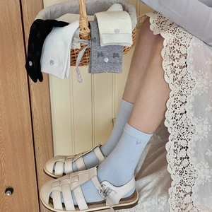 Chaussettes en coton avec broderie de nœuds en plusieurs couleurs sur fond bois