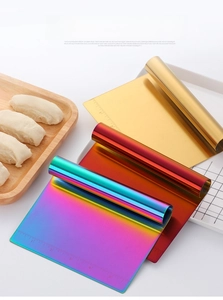 Close-up of stainless steel dough scrapers with measuring scales in multi-color finishes