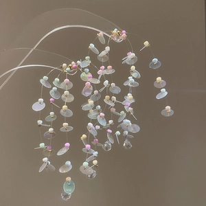 Macro view of colorful beaded tassel earrings with translucent discs and crystal drops