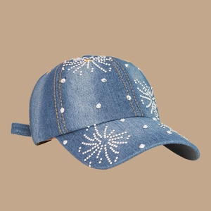Détail de la casquette de baseball en denim bleu avec étoiles en strass et coutures jaunes