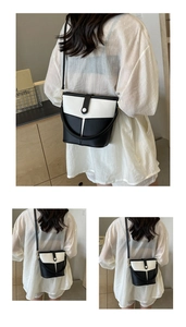 Borsa a secchiello bicolore bianco e nero con patta a contrasto sulla spalla